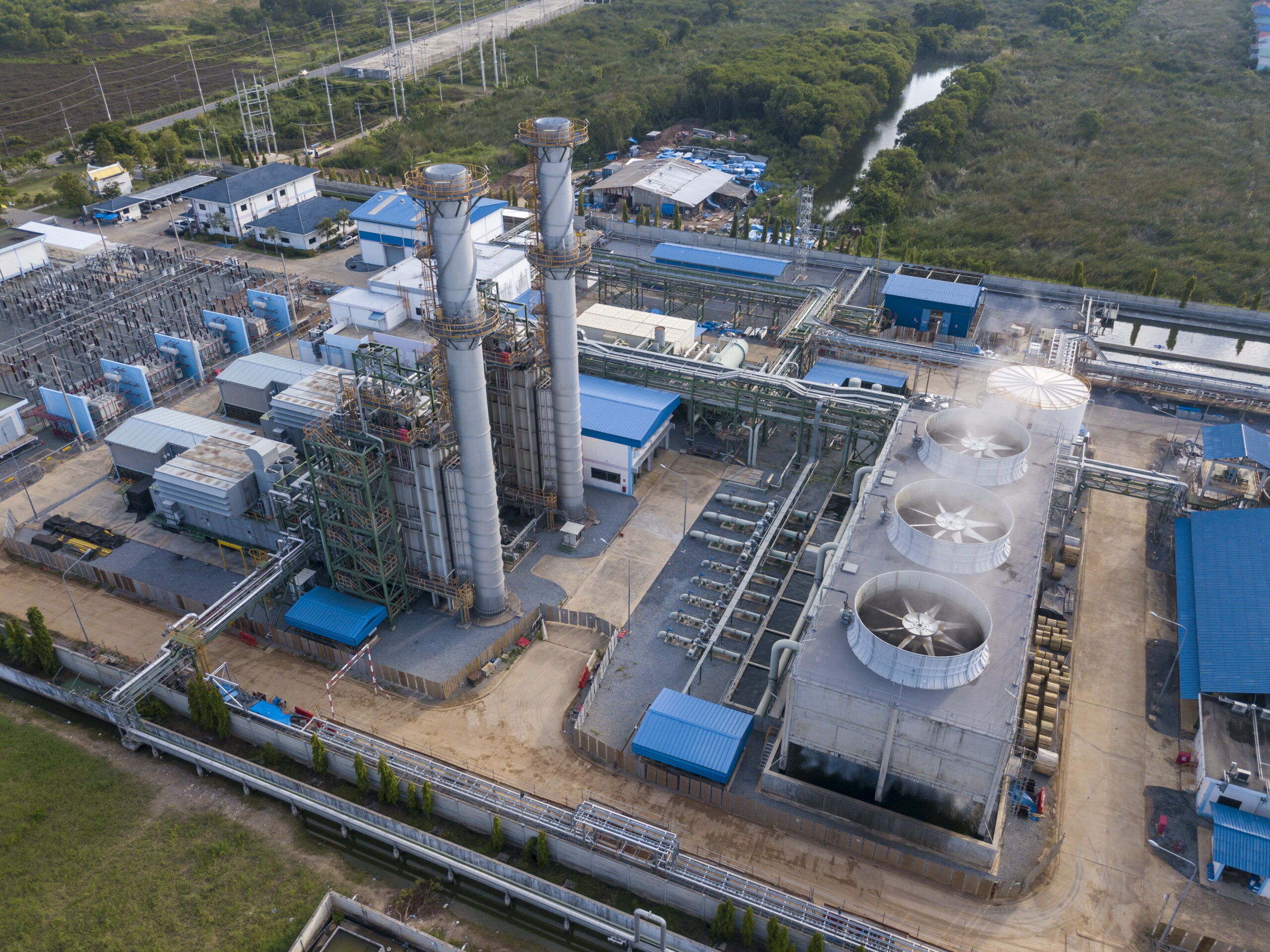 Aerial view of gas turbine power plant factory with cooling system fan in operation which producing electricity while causing pollution and releasing carbon dioxide which create global warming